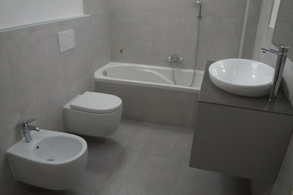 Renovare baie modernă cu sanitare suspendate și cadă